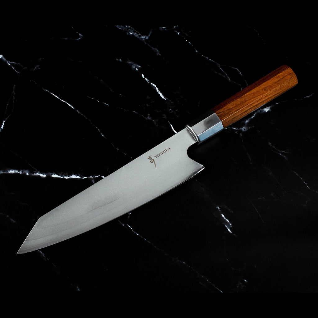 Couteau Kiritsuke japonais Yoshida posé sur marbre noir, finition acier 440C