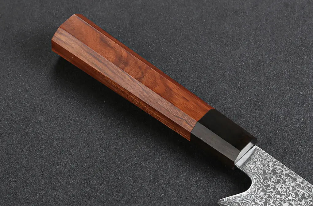 Détail du manche en bois de rose d’un couteau japonais Kiritsuke en acier Damas