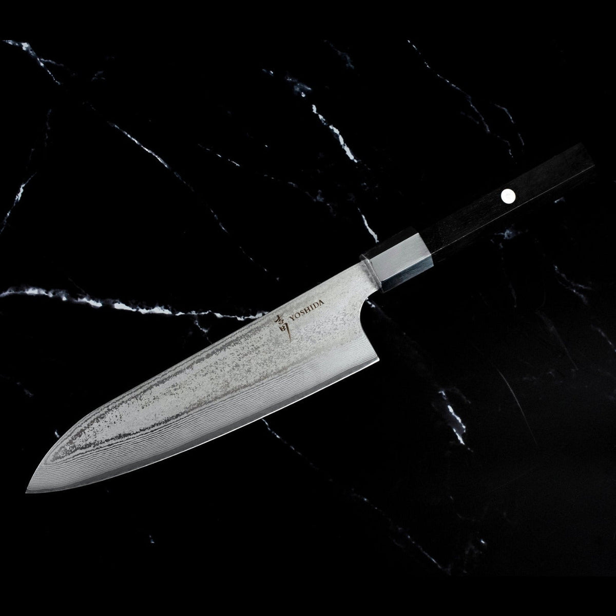 Profil du Santoku 18 cm AUS-10 vendu avec le Kiritsuke 20 cm : lame Damas et manche en bois noir, sur marbre