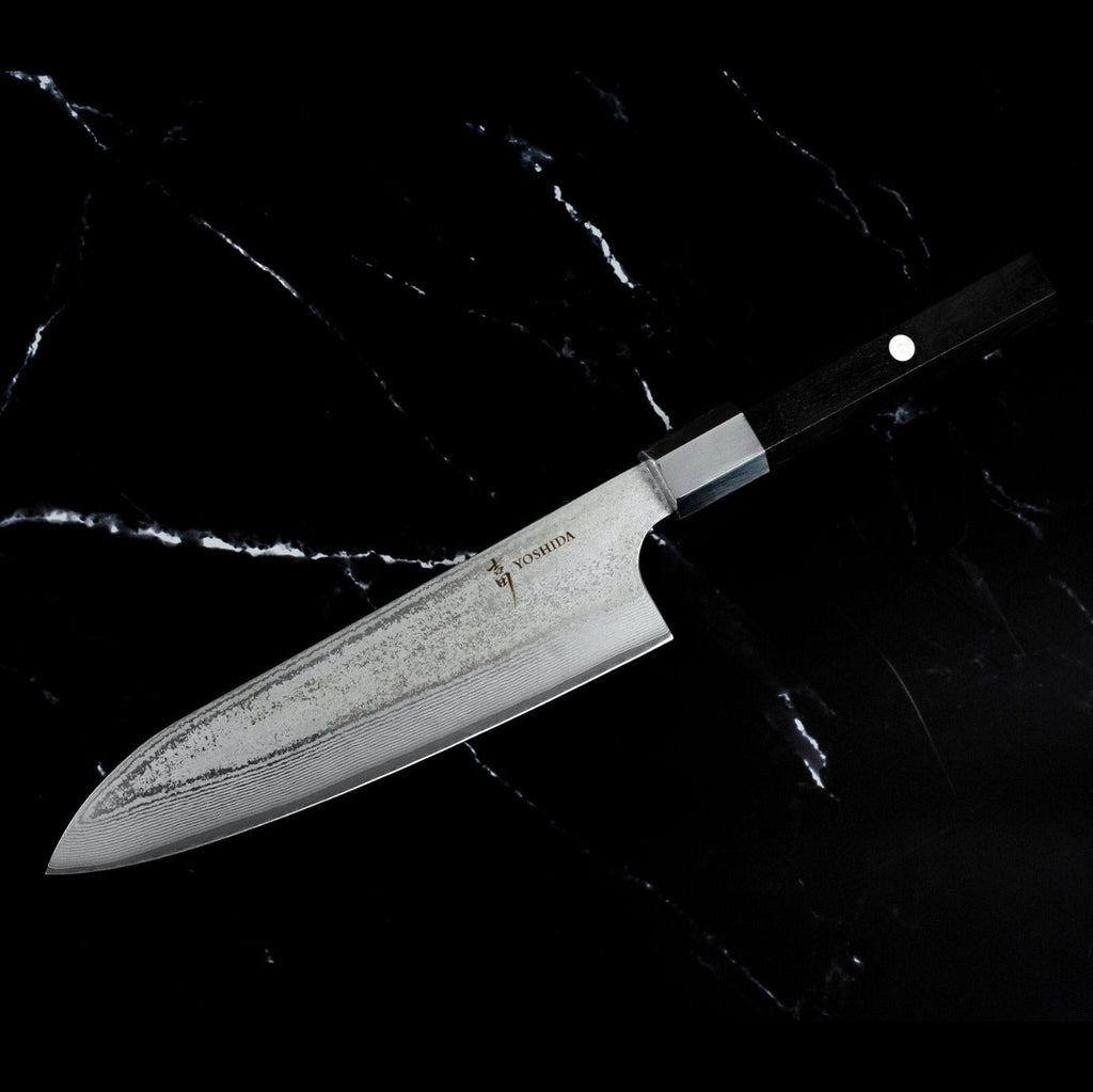 Profil du Santoku 18 cm AUS-10 vendu avec le Kiritsuke 21 cm : lame Damas et manche en bois noir, sur marbre